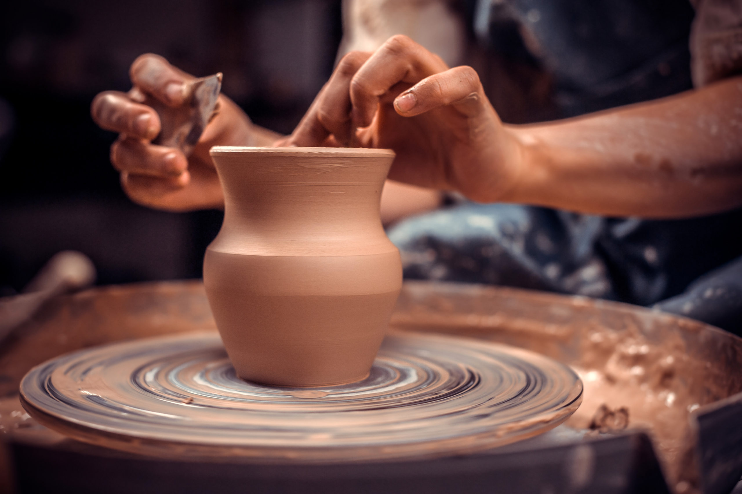 Un potier travaille un vase sur un tour.
